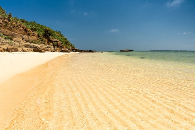 Transparante ondiepe zee over een prachtig golvend zand aan de waterkant. Klif strand. Iriomote eiland.