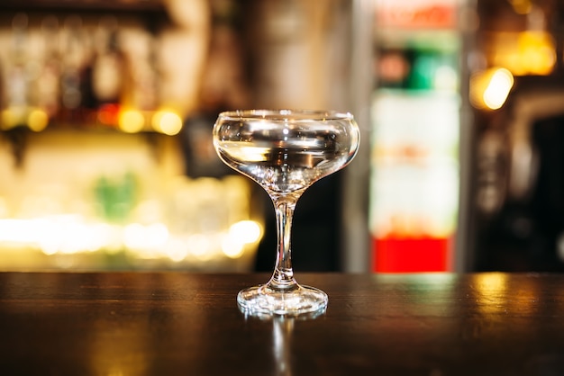 Transparent beverage in glass on bar counter