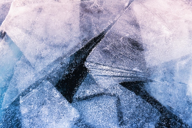 Transparent blue ice with cracks and ice floes on Baikal lake in winter