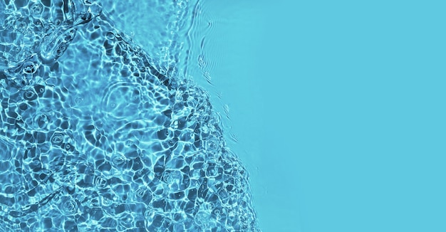 波紋とコピースペースで背景をはねかける透明な青い水面
