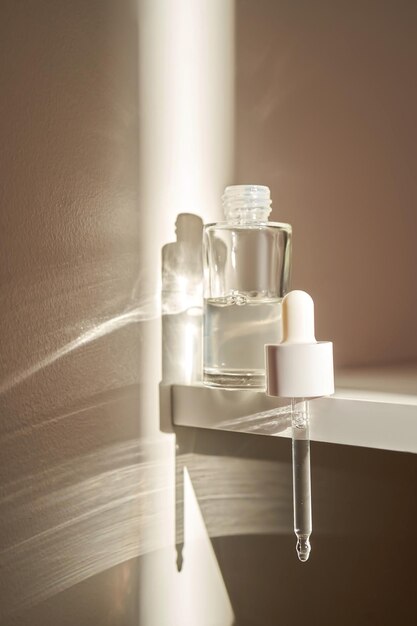 A transparent bottle of serum under the morning sun