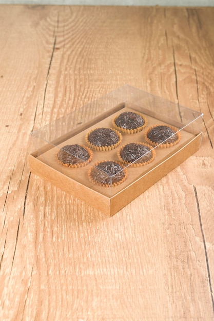 Transparent box full of Brazilian Sweet Brigadeiro on a wooden desk Vegan version