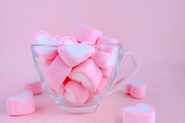 Transparent coffee cup filled with marshmallow. Cute pastel background, 