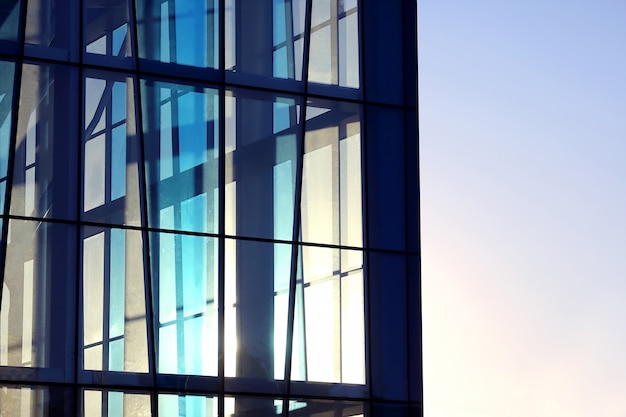 The transparent facade of the building against the sky and the sun