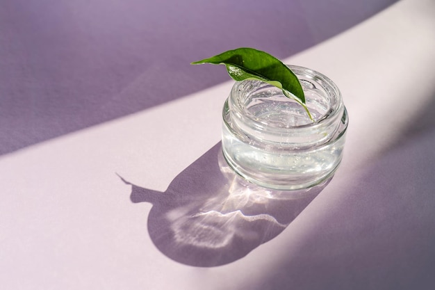 Transparent gel in a jar on a lilac background