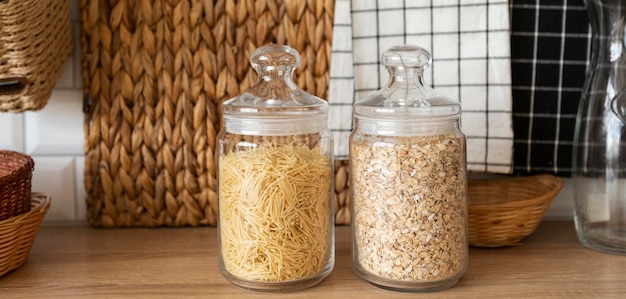 transparent glass jars with pasta and oatmeal on the kitchen table jar of vegetarian food