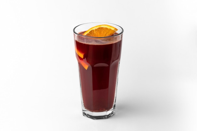 자연 그림자가 있는 흰색과 회색 배경에 분리된 얇게 썬 오렌지와 함께 짙은 빨간색 상쾌한 겨울 음료 Mulled 와인 한 잔