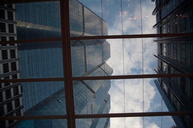 A transparent glass roof with blue skyscraper in\
background