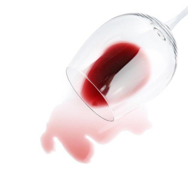 Transparent glass and spilled exquisite red wine on white background top view