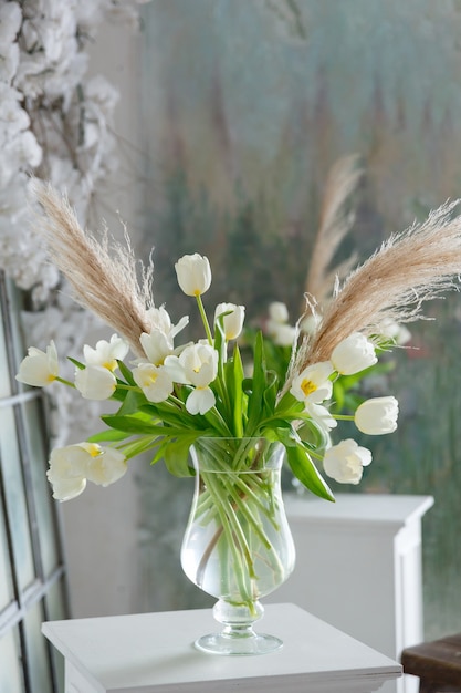 Transparent glass vase with bouquet of flowers of tulips