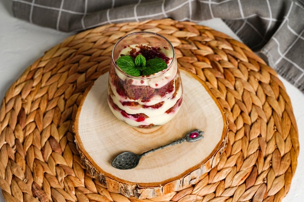 Transparent glass with layered dessert chocolate cake and whipped cream berries