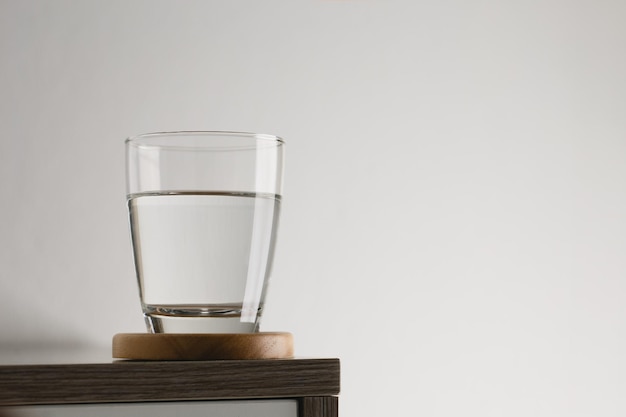 Прозрачное стекло с водой на деревянном столе