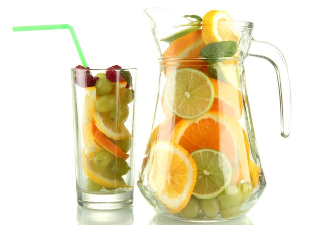 透明な瓶とグラスに柑橘系の果物とラズベリーを白で隔離
