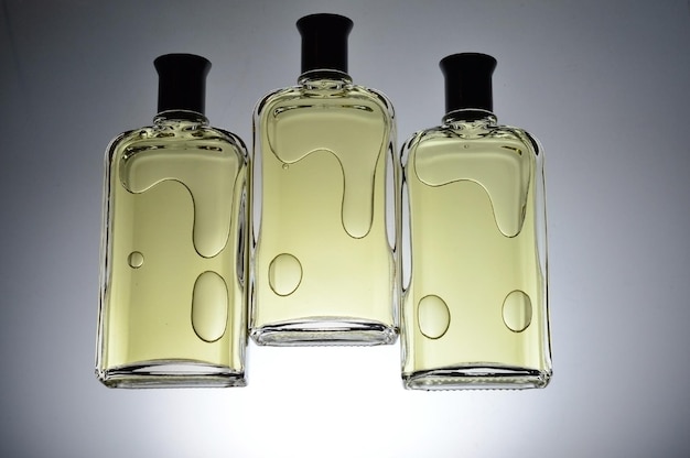 Transparent jars with perfume lie on a light background Closeup