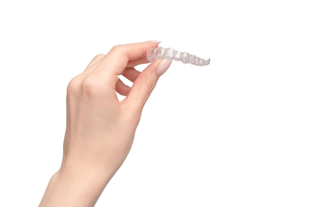 Transparent mouth guard in a woman's hand isolated