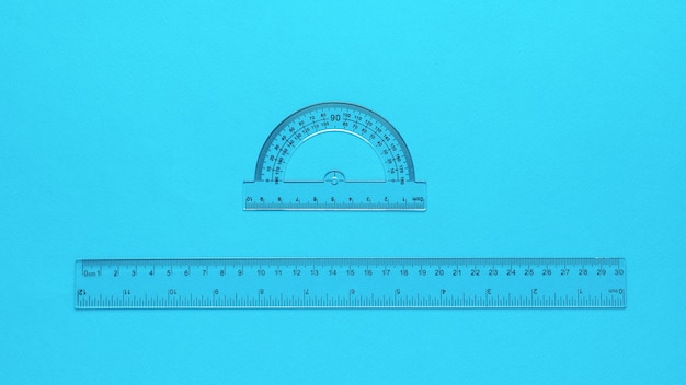 Transparent protractor and transparent ruler on a blue background