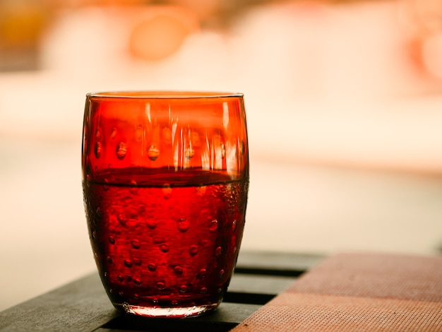 Transparent red glass with water on the table