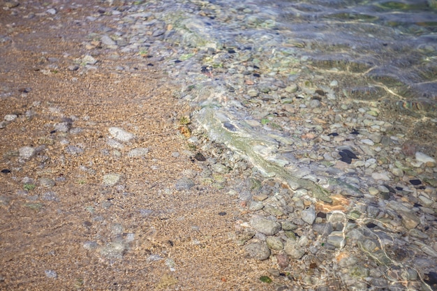 Transparent sea with pebbles texture
