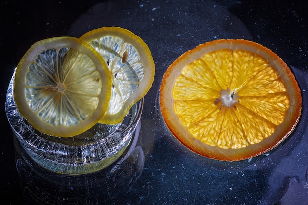 Transparent slices of oranges and lemons on the glass