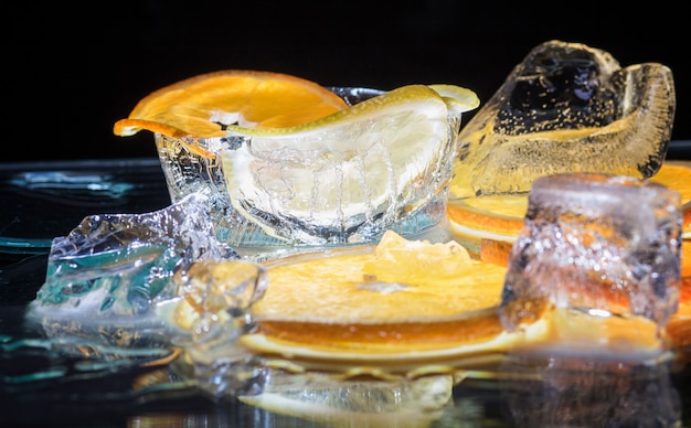 Transparent slices of oranges and lemons on the glass