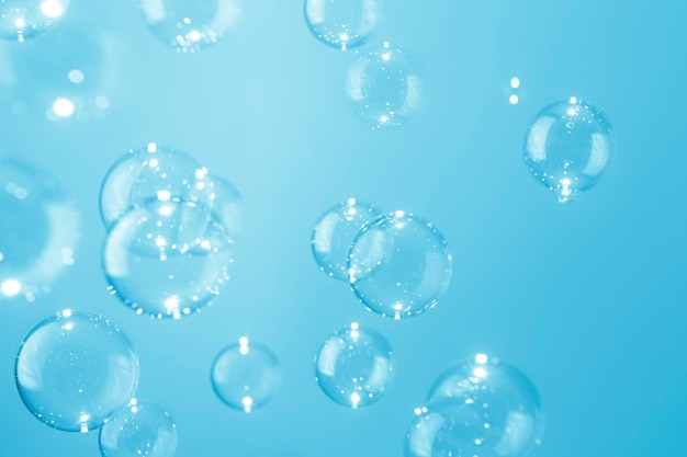 Прозрачные мыльные пузыри, плавающие на синем фоне