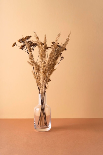 Photo transparent vase with dried flowers on a neutral background background copy space wabi sabi trend