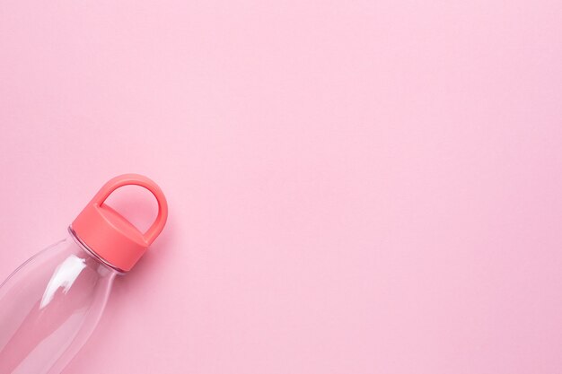 Transparent water bottle on pink