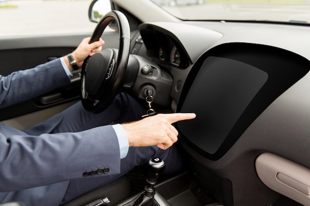 輸送、ビジネス、現代のテクノロジー、人々のコンセプト – 車を運転し、空のオンボード・コンピュータ画面に指を向ける男性の接写