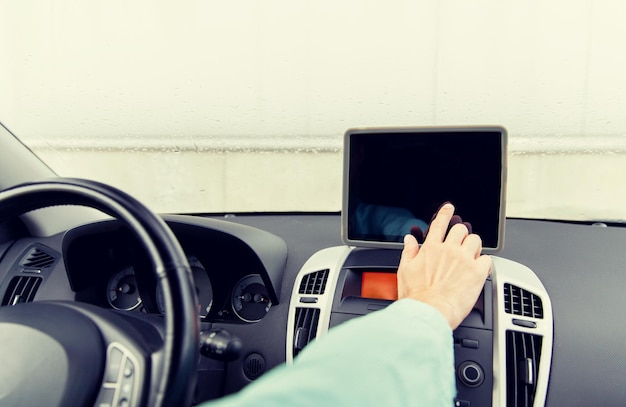 transport, business trip, technology, navigation and people concept -close up of young man with tablet pc computer driving car