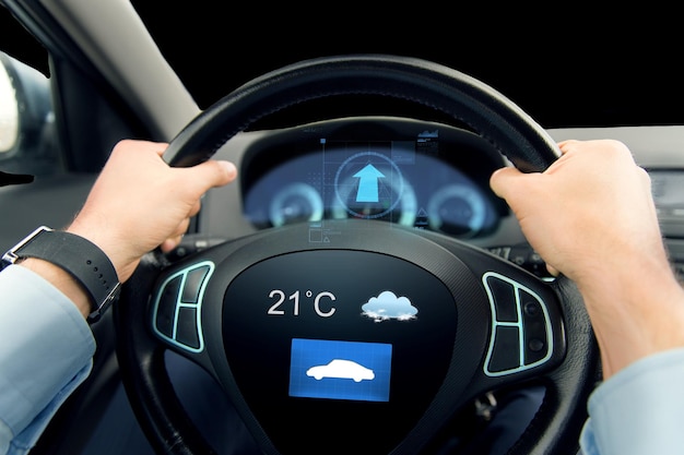 transport, business trip, technology and people concept - close up of male hands holding car wheel and driving with weather sensor on board computer screen