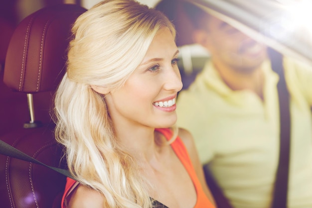 transport, leisure, road trip and people concept - happy man and woman driving car