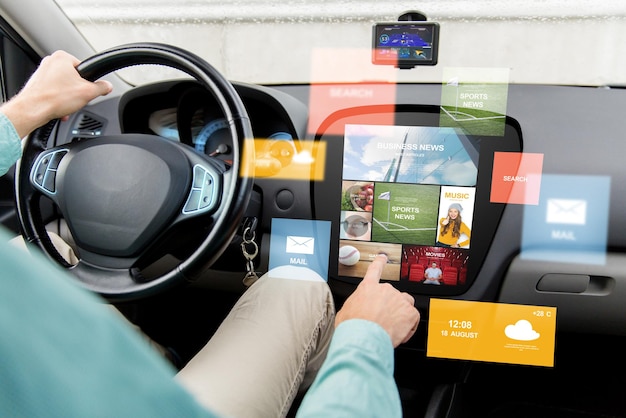 transport, modern technology, media and people concept - close up of man driving car with news on board computer screen