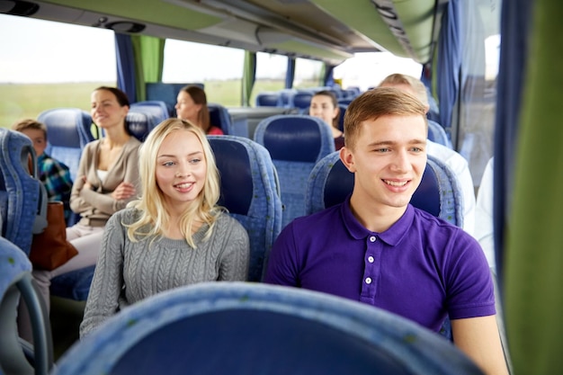 transport, toerisme, roadtrip en mensenconcept - gelukkig stel met groep gelukkige passagiers of toeristen in reisbus