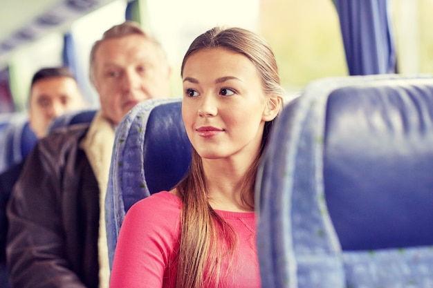 교통, 관광, 도로 여행, 사람 개념 - 여행 버스나 기차에 앉아 있는 행복한 젊은 여성