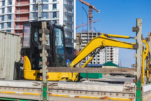 Transportation of a mini excavator to a construction site in a truck Compact excavator for earthworks