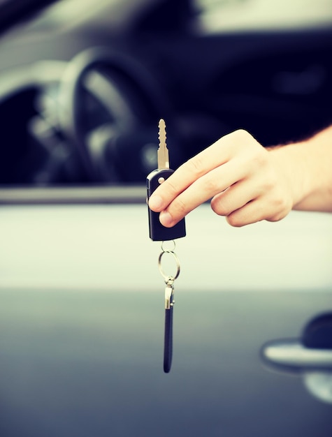 Concetto di trasporto e proprietà - uomo con la chiave dell'auto all'esterno