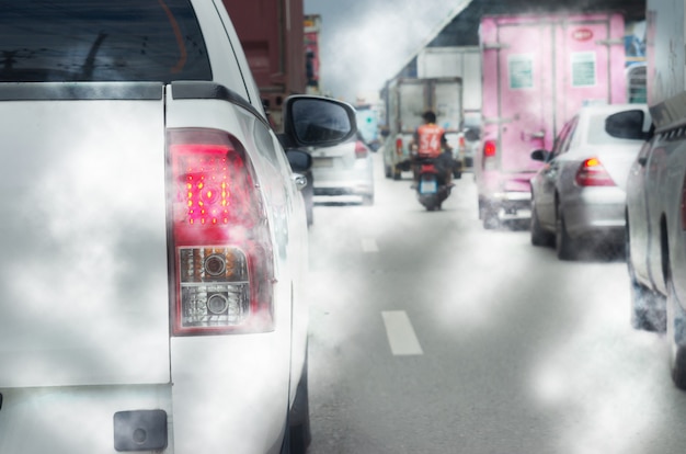교통 여행 대기 오염이 있는 도로의 교통 체증, 자동차 배기관의 연기. 자동차 미등에 초점.