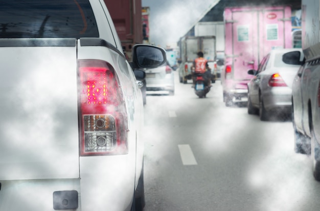 Transportation travel traffic jams on roads with air pollution,
smoke from car exhaust pipes. focus on car taillights.