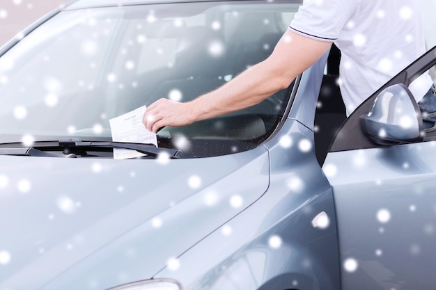 transportation and vehicle concept - close up of parking ticket on car windscreen