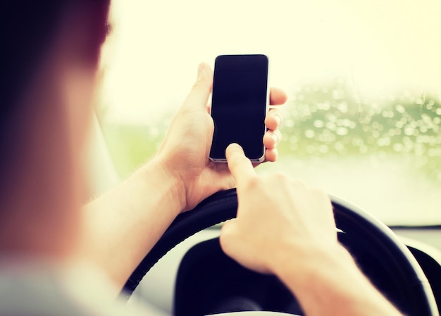 transportation and vehicle concept - man using phone while driving the car