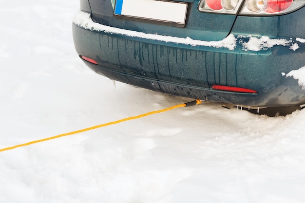 transportation, winter and vehicle concept - closeup of towing car with towing rope