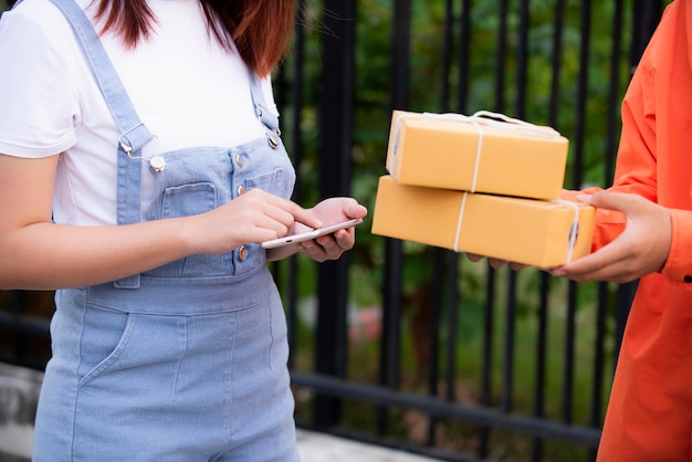 Photo transporter dressed in orange uniform delivers parcels