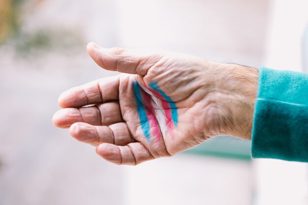 Transsexual man shows his hand with painted transsexual flag