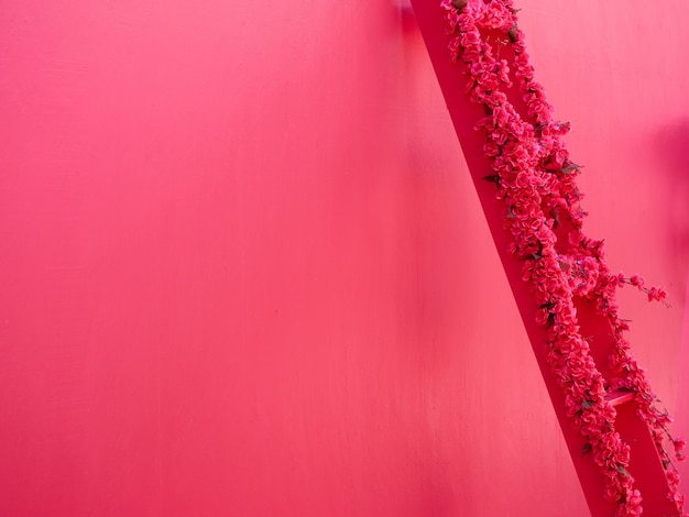 Trap versierd met roze bloemen, roze muur achtergrond. Kopieer ruimte. Plaats voor tekst.