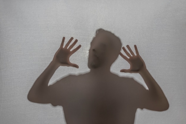 Photo trapped man screaming behind fabric