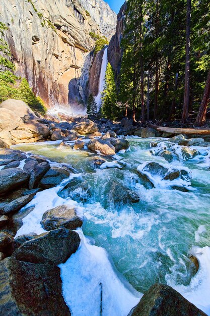 Trapsgewijze ijzige watervallen over ijzige wandelingen met regenboog naast Lower Yosemite Falls