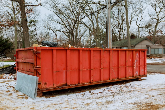 Trash bin at the side of street in winter with lip open