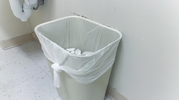 Photo a trash can with a plastic bag in it