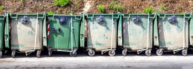 Trash or garbage cans standing in a row outdoors