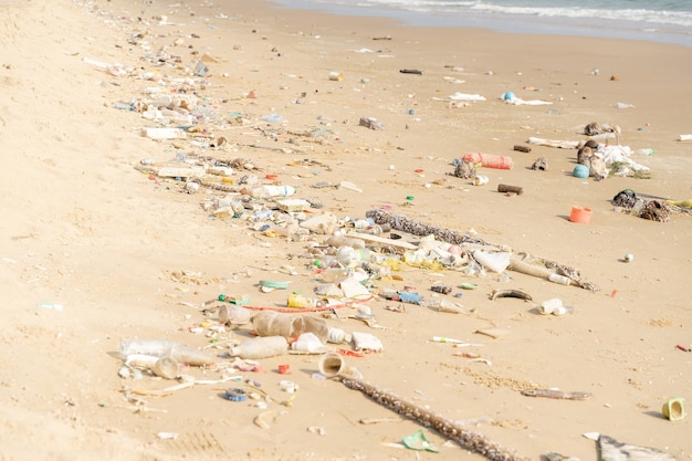 熱帯のビーチのゴミ箱。プラスチック汚染環境問題。ペットボトルなどのゴミが浜辺に打ち上げられました。